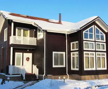 Зимнее фото деревянного дома из клееного бруса, построенного по проекту №2-265 от компании Аттика
